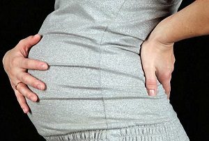 Рисуване усещания в долната част на гърба по време на бременност: какво се случва?
